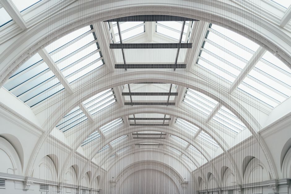 A modern architectural interior featuring elegant white arches and skylights in London.