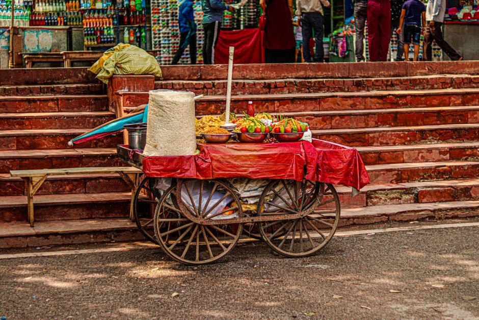 Vibrant street food scene with a wooden cart offering fresh snacks in a bustling market setting.