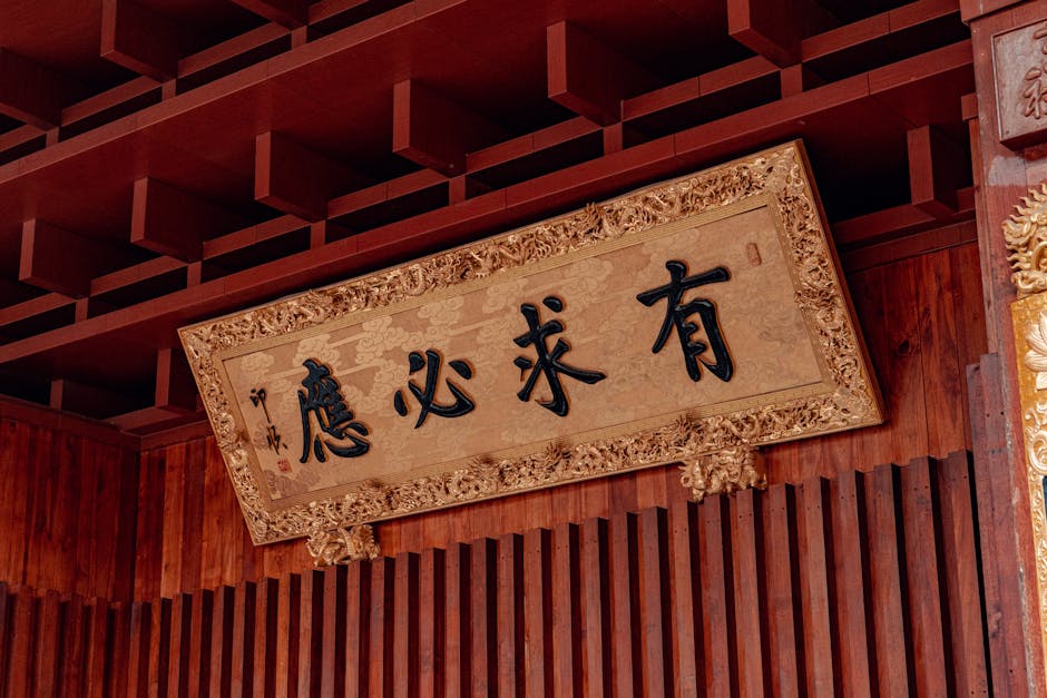 Ornate Chinese sign in a temple setting, featuring golden embellishments and traditional script.