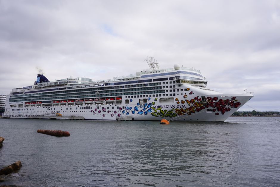 The Norwegian Gem cruise ship docked at a port with artistic exterior design and calm waters.
