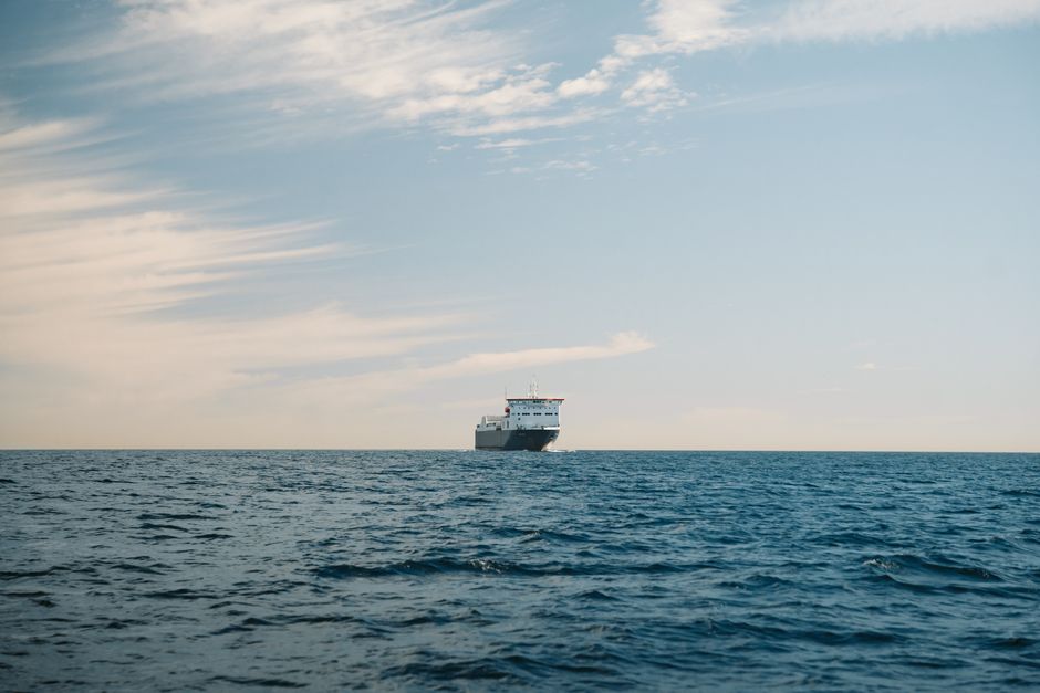 A cargo ship sailing on the calm waters of Baja California Sur, México, under a clear sky.