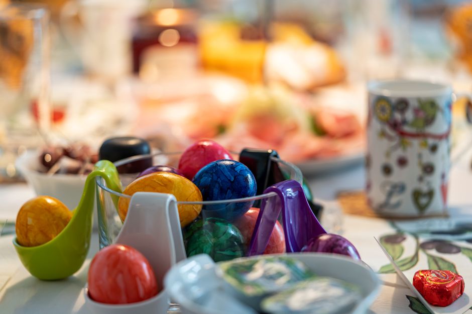 Vibrant Easter eggs in holders on a beautifully set holiday table indoors.