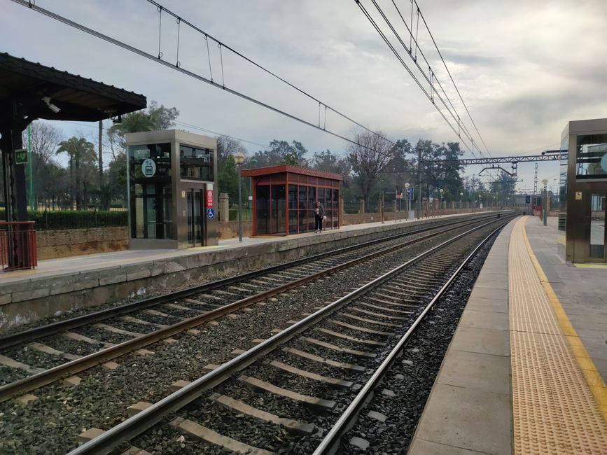 Empty railway station platform in Dos Hermanas, España, showing tracks and station elements.