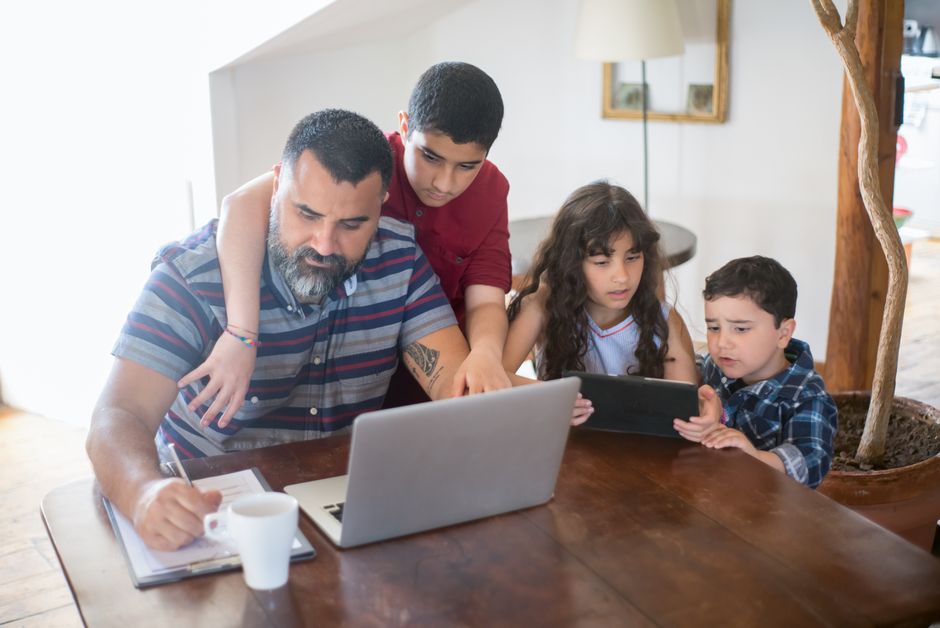 Father and children planning the year's family holidays on a laptop at home