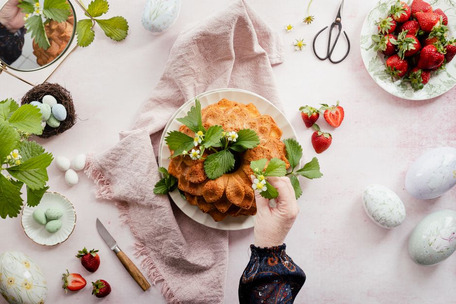 Top view of a festive cake with strawberries and Easter decorations.