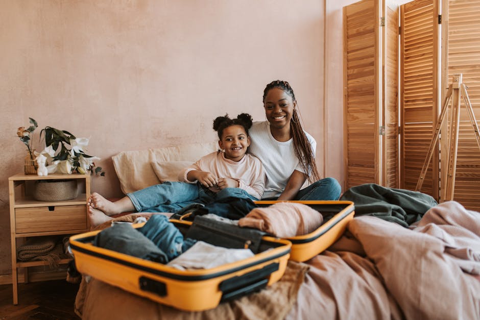 Smiling mother and daughter packing luggage together in cozy room.