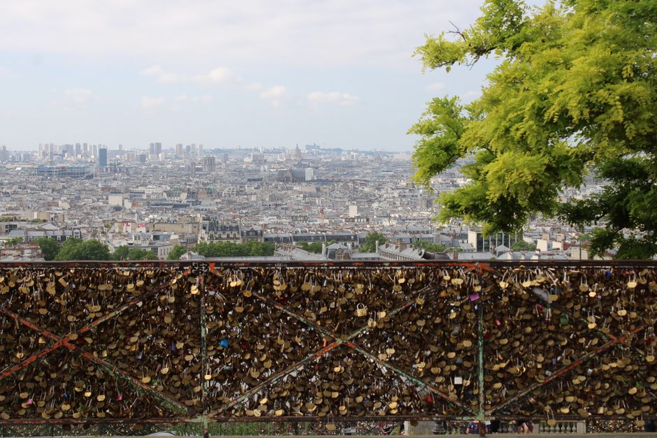 A view of Paris with love locks on a fence, capturing the city's romantic atmosphere.
