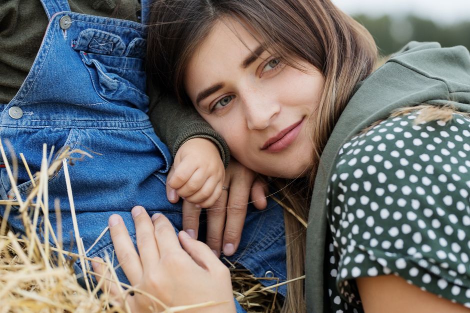 Close-up of a mother and child bonding in a serene outdoor setting.