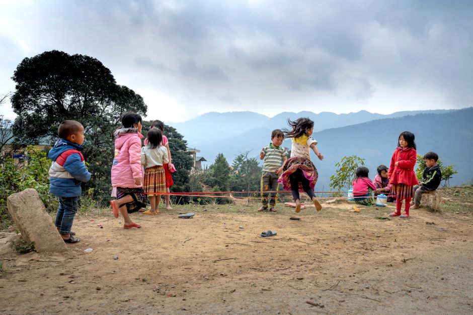 Group of children enjoying a playful day outside in a rural mountain landscape.
