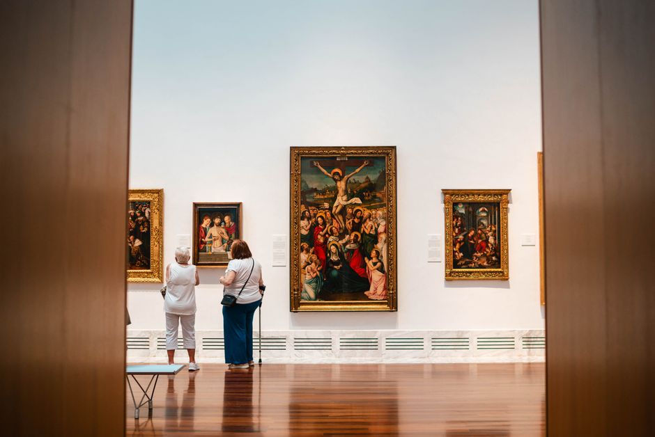 Visitors explore fine art paintings in a València gallery, capturing cultural appreciation.