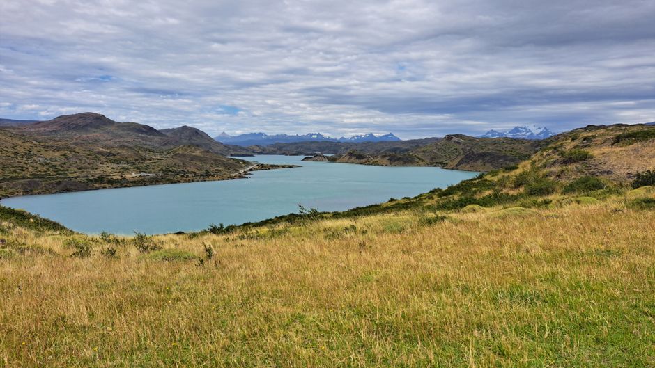 Breathtaking view of Lago Toro in Patagonia surrounded by mountains under a cloudy sky.